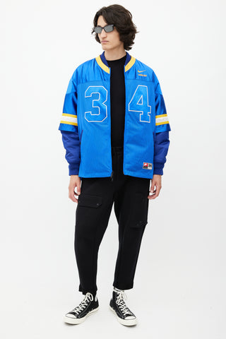 Nike x Ambush Blue 
Yellow Jersey Bomber Jacket