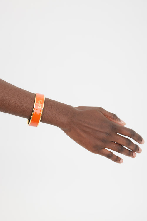 Hermès Orange 
Gold Printed Logo Caleche Bangle