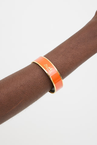 Hermès Orange 
Gold Printed Logo Caleche Bangle