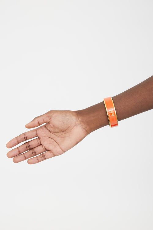 Hermès Orange 
Gold Printed Logo Caleche Bangle