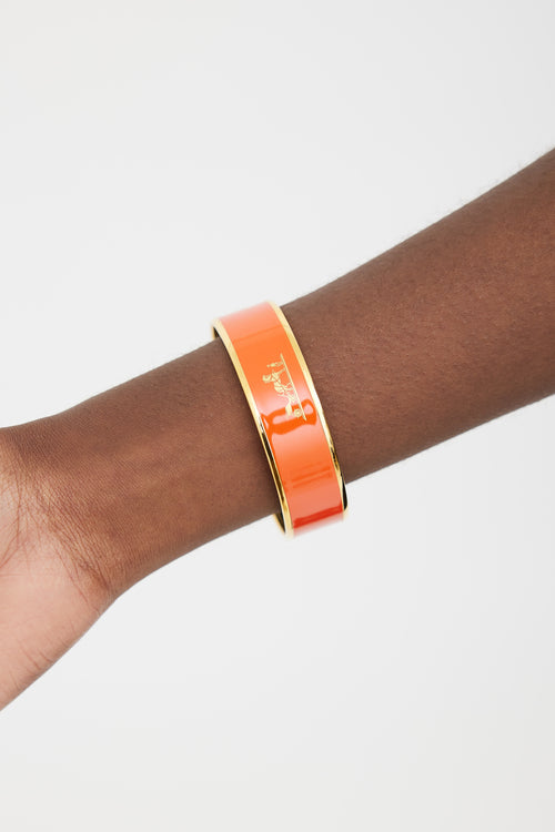 Hermès Orange 
Gold Printed Logo Caleche Bangle